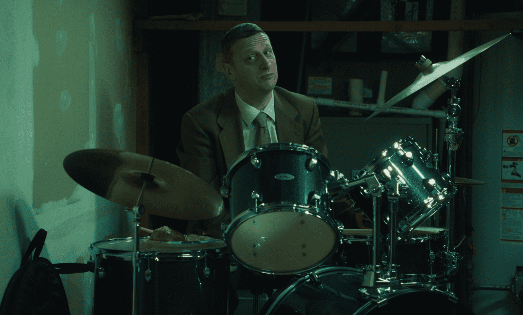 Tim Robinson sits behind the drums in Friendship